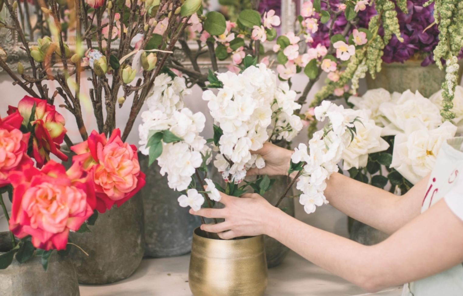 Artisan carefully selecting premium flowers for custom bouquet design